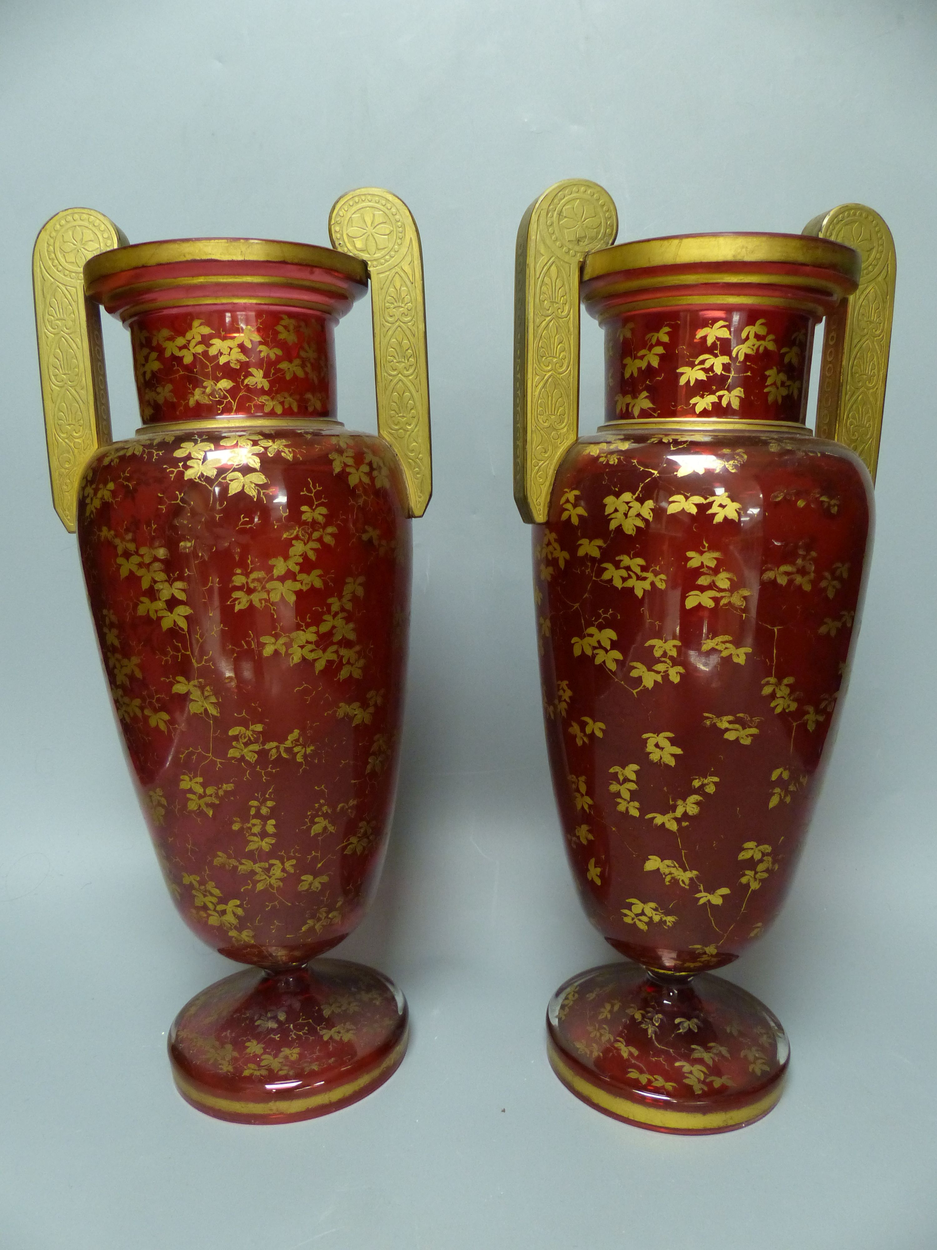 A pair of Bohemian gilt decorated ruby glass two handled vases, late 19th century, height 32cm